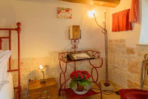 a room with a table with a phone and flowers at La Maison - Tenuta Colavecchio in Putignano