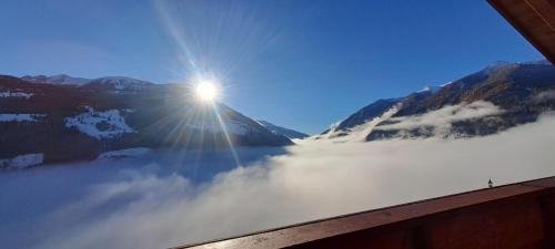 een uitzicht op de zon die opkomt boven een met mist bedekte berg bij Großstahlhof Mountain & Panorama View in San Giovanni in Val Aurina