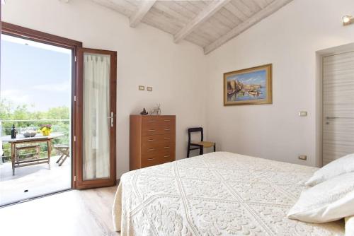 a white bedroom with a bed and a balcony at ClickSardegna Villa dei Limoni with pool close to the beach in Fertilia
