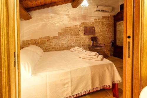 a bedroom with a bed with two towels on it at La Maison - Tenuta Colavecchio in Putignano