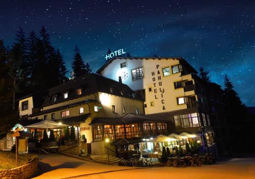 a hotel with a sign on top of it at night at Hotel Pahuljica in Vlasic