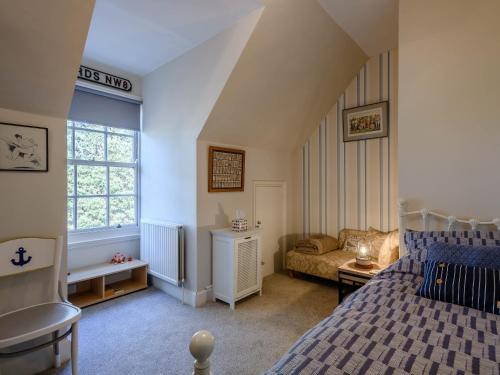 um quarto com uma cama, um sofá e uma janela em Hampsire House em Cromer