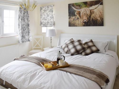 a white bed with a tray of food on it at Rudda Farm Cottage - Uk2492 in Staintondale