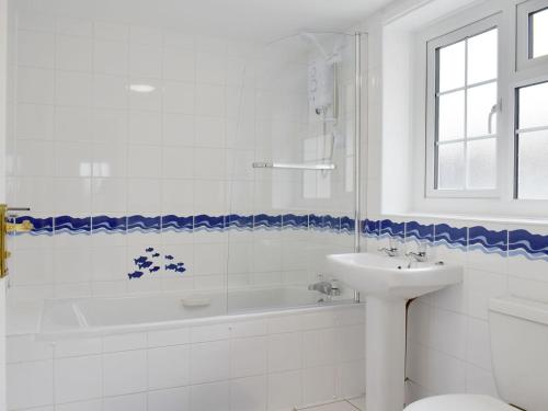 a white bathroom with a tub and a sink at Rudda Farm Cottage - Uk2492 in Staintondale