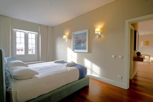 a bedroom with a large bed with white sheets and pillows at Cardosas Square Luxury Apartments by Porto City Hosts in Porto