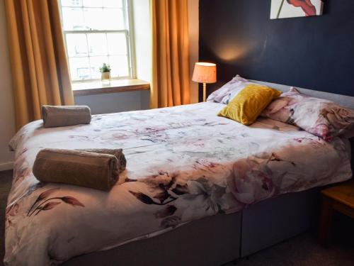 a bedroom with a large bed with flowers on it at Lochside Apartment in Inveraray