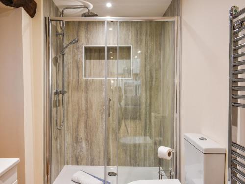a shower with a glass door in a bathroom at Tarn Cottage - Uk42803 in Mungrisdale