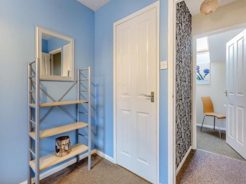Cette chambre est dotée de murs bleus et d'une porte blanche. dans l'établissement Cairnie View, à Aviemore