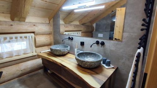 a bathroom with two sinks on a wooden counter at Böhmerwald Lodges in Ulrichsberg