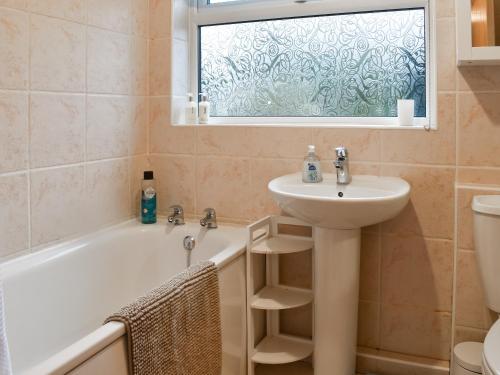a bathroom with a sink and a bath tub and a window at Crosslands in Penrith