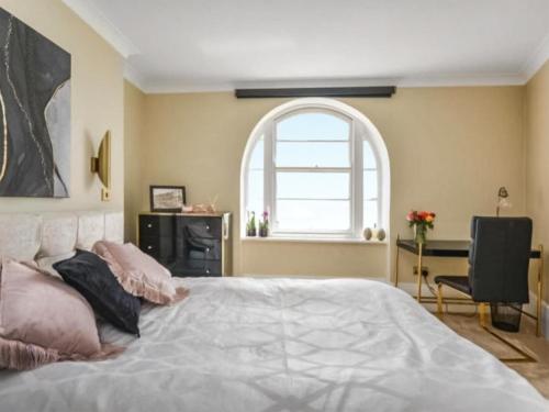 a bedroom with a large bed with a window at Wellington Views in Ramsgate