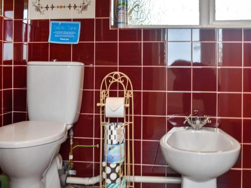 a bathroom with a toilet and a sink at The Stables in Ely