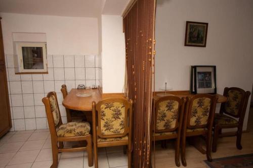 Maison du Bonheur في سراييفو: غرفة طعام مع طاولة وكراسي خشبية