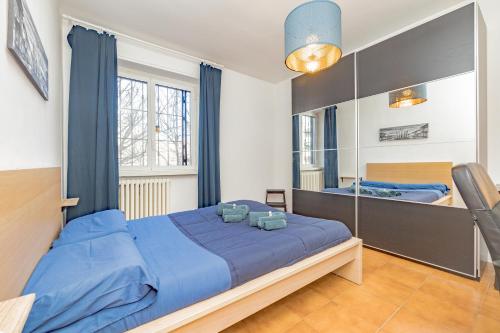 a bedroom with a blue bed and a mirror at Niguarda Hospital M5 Lilla 10 Home Away WiFi AC in Milan