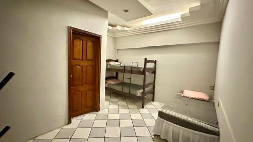 um quarto com 2 beliches e uma porta em Casa Piauí Hostel em Teresina