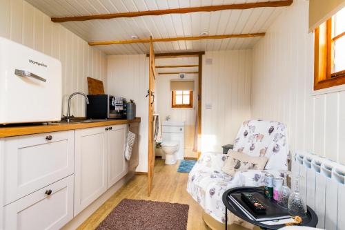 a small kitchen with a chair in a tiny house at Shepherds Hut, West Ayton, Scarborough in Scarborough