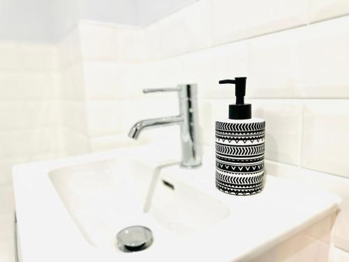 a black and white soap dispenser sitting on a sink at Dover luxury apartments, near Ferry in Dover