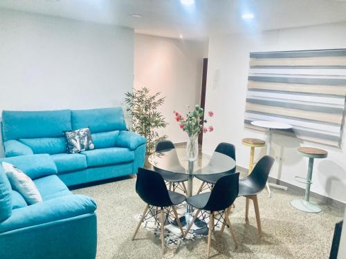 sala de estar con sofá azul, mesa y sillas en Pasa Tiempo, en Córdoba