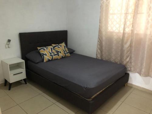 ein schwarzes Bett in einem Zimmer mit Fenster in der Unterkunft APARTAMENTO 3 habitaciones y piscina a solo 15 minutos del aeropuerto in Panama-Stadt