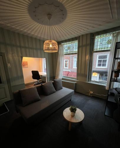 uma sala de estar com um sofá e uma mesa em Appartement centrum Delft em Delft