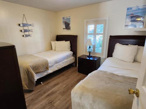 a bedroom with two beds and a window at Eden Roc Apartments in Ocean City
