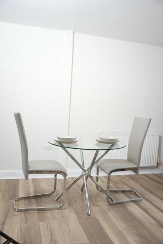 two chairs and a glass table in a room at Stylish Pride Park DERBY Apartment - Free WIFI, Parking in Derby