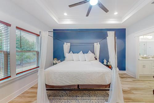 a bedroom with a bed with a blue wall at Driftwood Dreams in Panama City Beach