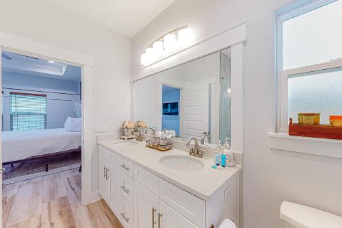 Baño blanco con lavabo y espejo en Driftwood Dreams, en Panama City Beach