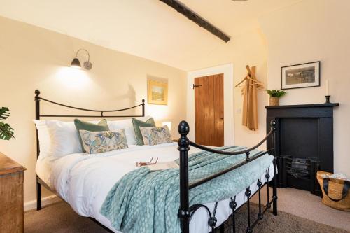 a bedroom with a bed and a fireplace at Yew Tree Cottage in Ayton