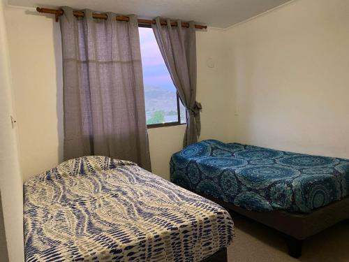 um quarto com 2 camas e uma janela em Departamento Equipado em Copiapó