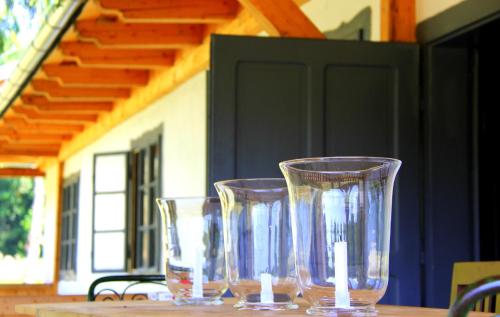 three clear glasses sitting on a wooden table at Dobrica Hunting Lodge in Bixad