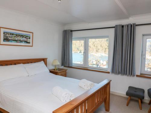a bedroom with a bed and two windows at Leeward in Dartmouth