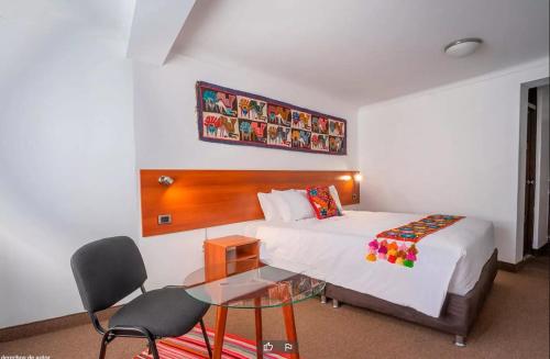 pokój hotelowy z łóżkiem i szklanym stołem w obiekcie Hotel Romero Cusco w Cuzco