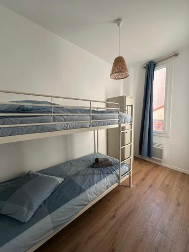 sypialnia z 2 łóżkami piętrowymi i lampką nocną w obiekcie Le Mourillonnais w mieście Tulon
