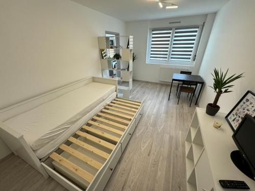 une chambre avec un lit, un bureau et une fenêtre dans l'établissement Studio calme à 15min du centre, à Strasbourg