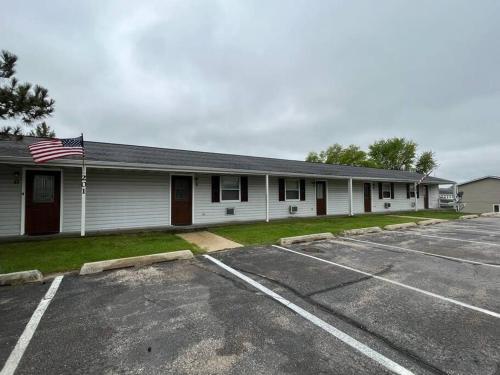 トーマにあるTomah Apartment A - E Veterans Stの駐車場内のアメリカ旗の建物