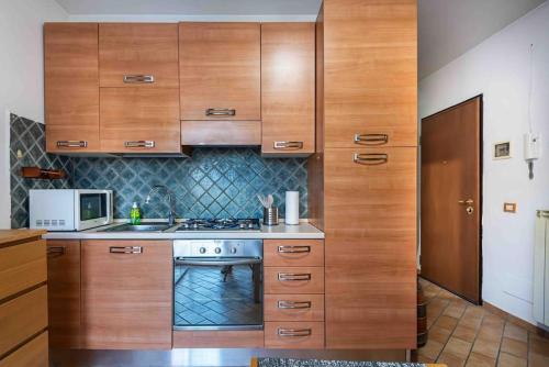 a kitchen with wooden cabinets and a stove at Casa della Tati in Segrate