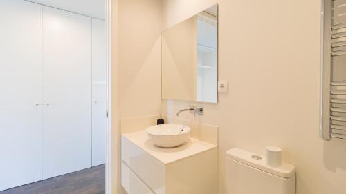 uma casa de banho branca com um lavatório e um WC em Nice Circunvalação Studio I By Unique Hosts em Senhora da Hora