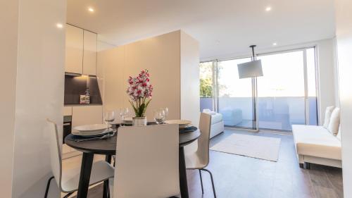 a dining room and living room with a table and chairs at Nice Circunvalação Studio I By Unique Hosts in Senhora da Hora