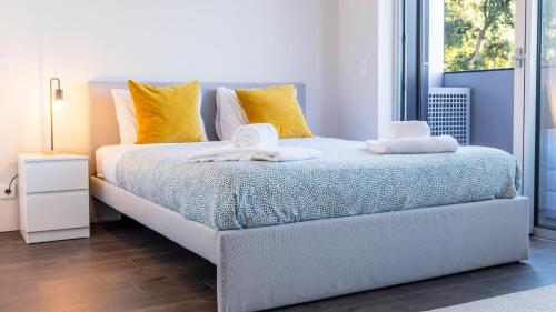 a bedroom with a bed with yellow and white pillows at Nice Circunvalação Studio I By Unique Hosts in Senhora da Hora