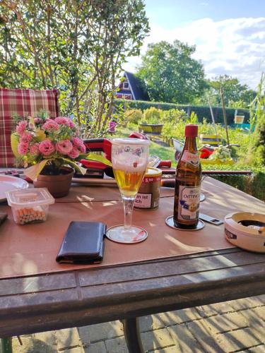 a table with a bottle of beer and a glass at Remo Garten in Neubrandenburg