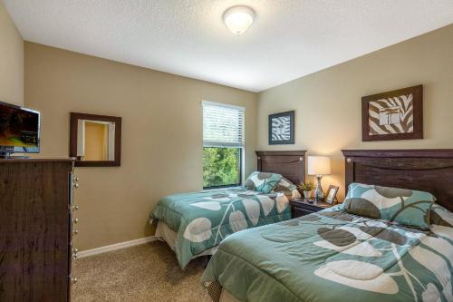 een slaapkamer met 2 bedden, een tv en een raam bij Cypress Pointe at Ellis Exclusive Villas in Davenport