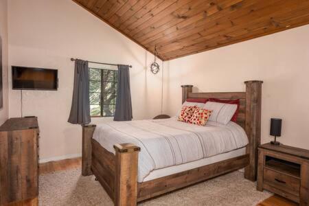 a bedroom with a bed in a room with a window at Cedar Ridge Hot Tub BBQ Sleeps 8 in Oakhurst