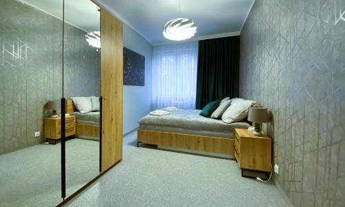 1 dormitorio con cama y espejo grande en Nero Apart Częstochowa en Częstochowa