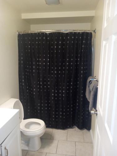 a bathroom with a black shower curtain and a toilet at One bedroom with free parking in Schenectady