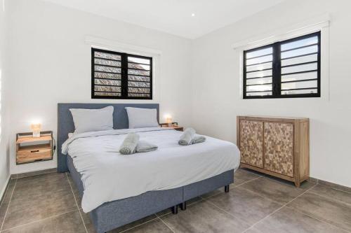 a bedroom with a large bed with two pillows on it at Villa Mambo Royale in Willemstad