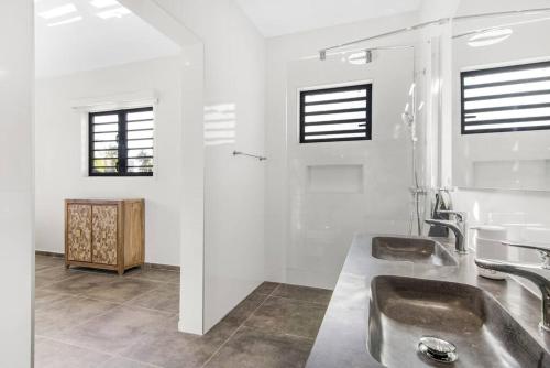 a bathroom with two sinks and two windows at Villa Mambo Royale in Willemstad