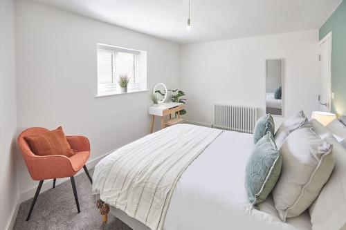 um quarto branco com uma cama e uma cadeira em Stunning Seaview 2 Bedroom Apartment em Redcar