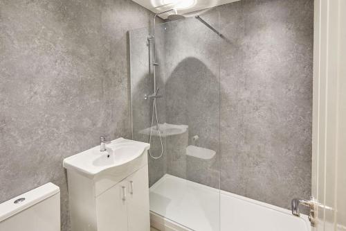 uma casa de banho com um chuveiro, um WC e um lavatório. em Stunning Seaview 2 Bedroom Apartment em Redcar