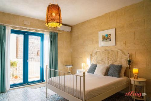 1 dormitorio con cama y ventana grande en A remarkable Eco Home in Gozo, en Nadur